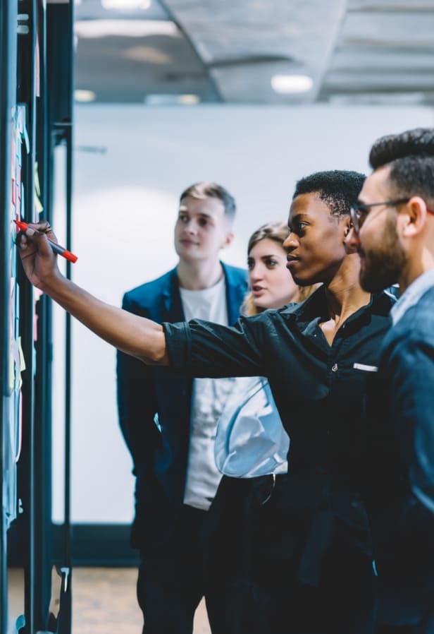 Jeunes professionnels collaborant devant un tableau